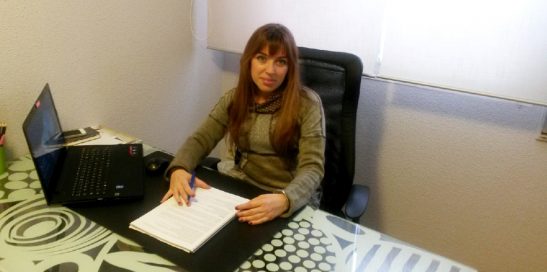 Imagen actual de Celia Rodríguez sentada en una mesa frente a un ordenador.