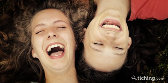 imagen humor en el aula: Dos niñas con las cabezas juntas riendo