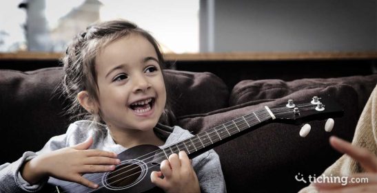 Niña con una guitarra para ilustrar las 8 razones para aprender música desde pequeños