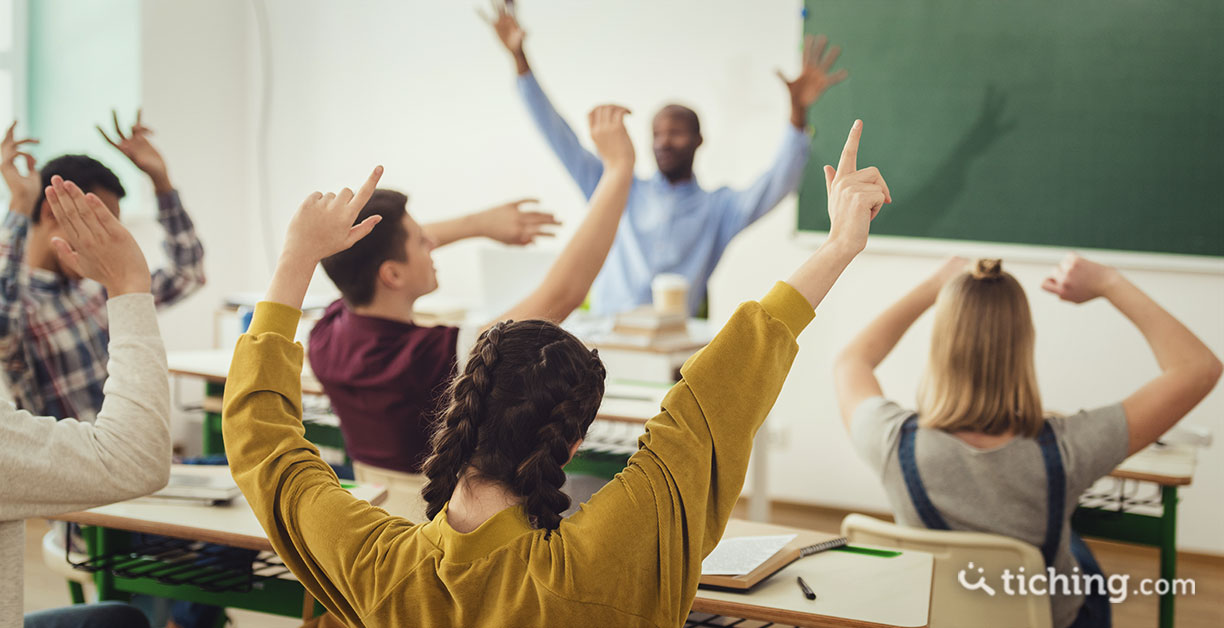 Imagen del artículo una metodología basada en la realidad de los jóvenes: adolescentes en clase con las manos levantadas