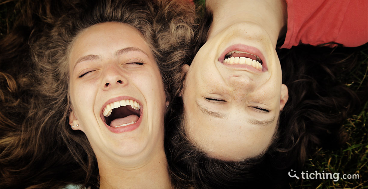imagen humor en el aula: Dos niñas con las cabezas juntas riendo